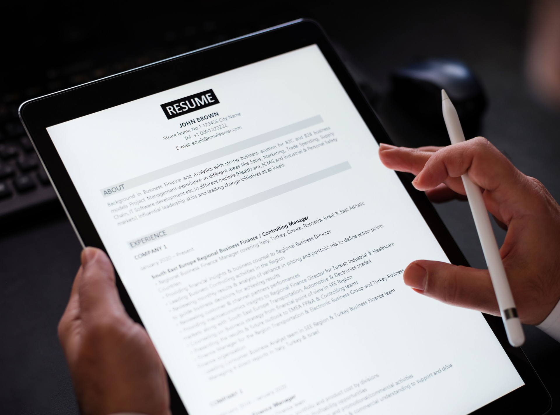 Businessman Reading A Resume On Digital Tablet To Hire Correct Personnel